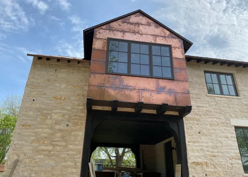 Copper metal panel facade on a stone building for Roof Repair in The Woodlands