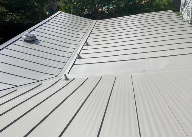 Solar attic fan installed on a metal roof for Roof Ventilation in The Woodlands