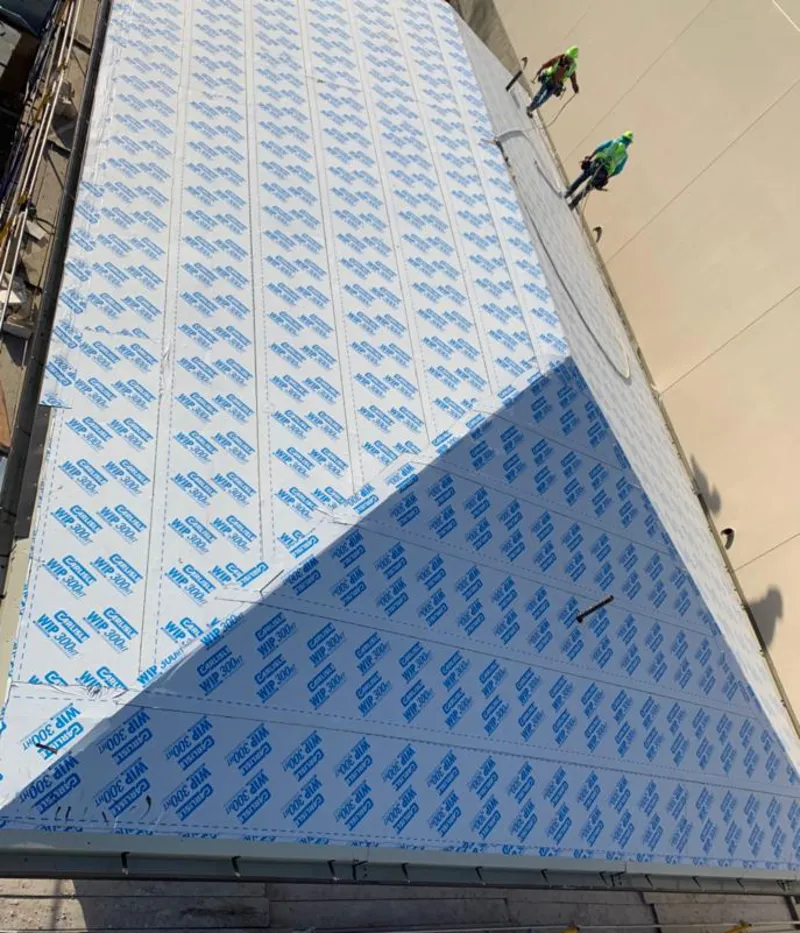 Professional roofers installing underlayment on a metal roof in The Woodlands